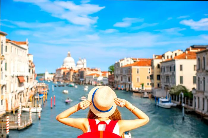 Grand Canal with woman traveler in hat on the Academia bridge in Venice