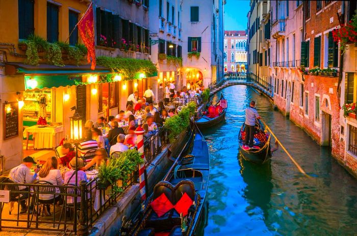 View of a canal in Venice, Italy at night, featuring gondolas