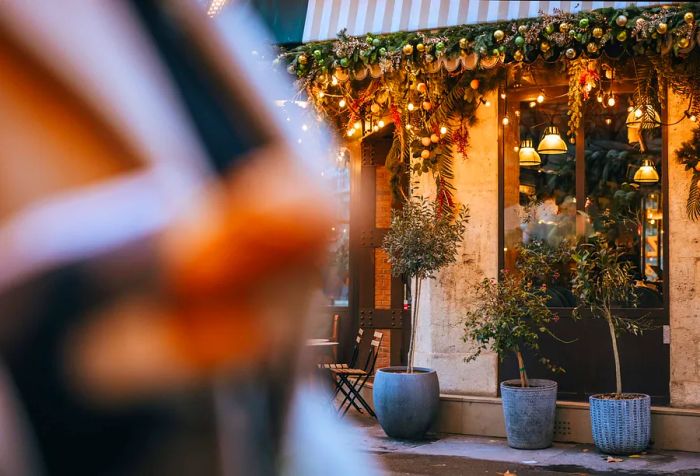 The restaurant window was beautifully adorned for the holidays with lights and greenery on either side.