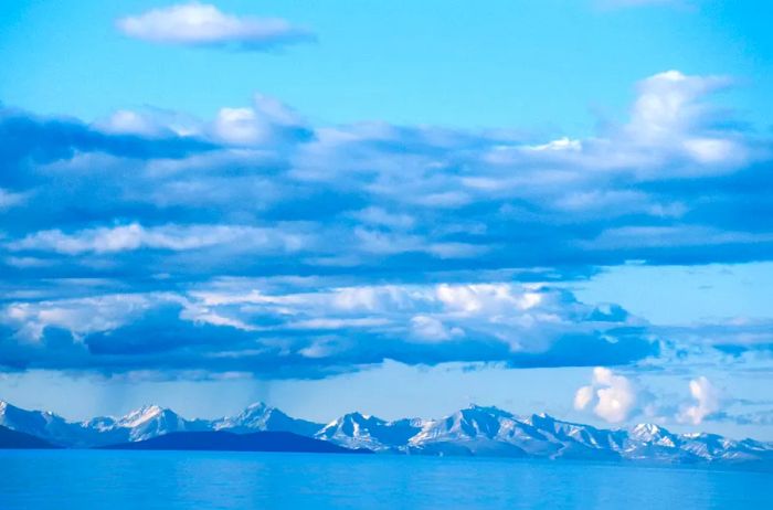 Snow-capped mountains frame the expansive blue lake in Mongolia