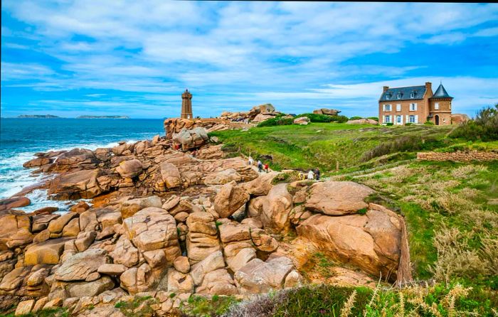 Waves crashing against a pink granite shoreline, the Sentier des Douaniers (Old Customs Officers Path), and a view of the Ploumanac'h lighthouse