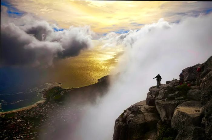 The view of Table Bay from Table Mountain showcases the sea, mist, homes, and people of Cape Town, South Africa.