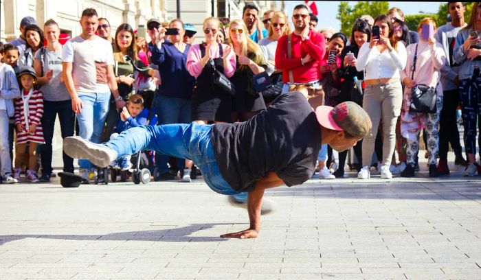 A break dancer showcasing their skills in front of an audience on the streets of Paris.