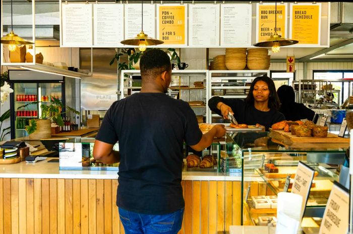 A woman serves a man at the Hoghouse Bakery in Cape Town, South Africa