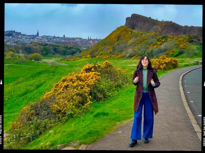 A woman strolling in Scotland with Arthur's Seat in the background