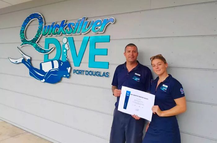 Chris Snel and Emma O'Brien proudly displaying a certificate from the Adaptive Services Facility