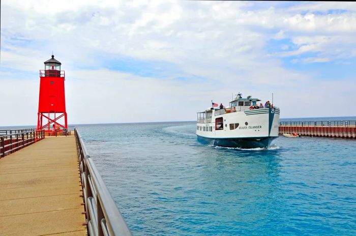 The Beaver Islander ferry gliding past the Charlevoix South Pier Lighthouse in the Pine River Channel between Lake Michigan and Lake Charlevoix