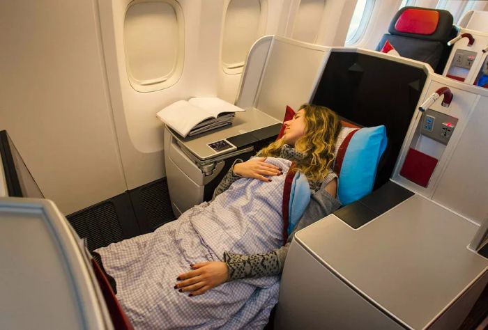 Woman resting comfortably in a business class seat on an airplane