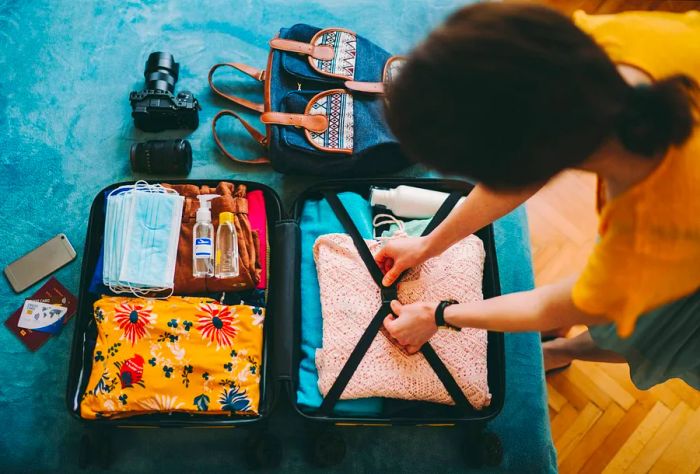 A woman securing her luggage with elastic straps.