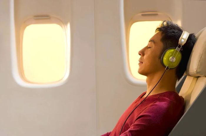 THEME_AIRPLANE_AIRLINE_PERSON_HEADPHONES_INFLIGHT