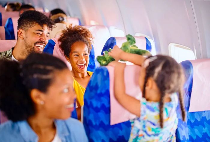 A joyful family with a child relaxes inside an airplane.