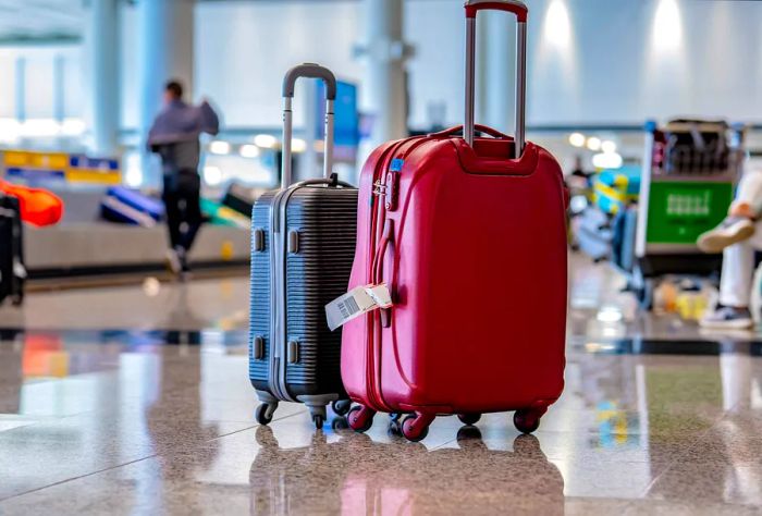 Luggage belonging to travelers is neatly organized on the spotless airport terminal floor.