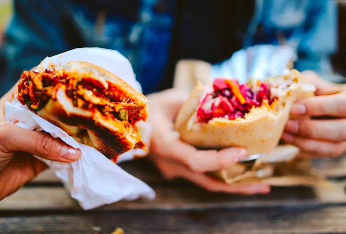 Two friends indulge in a Texas-style pulled pork sandwich and a falafel burger.