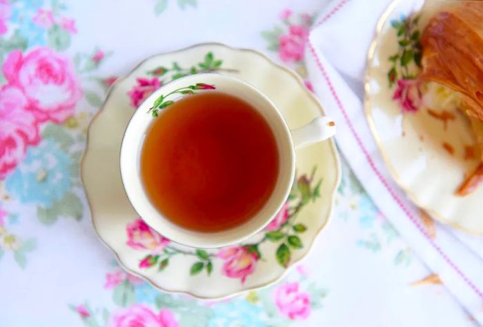 A delightful cup of tea presented in a charming pink rose cup and saucer.