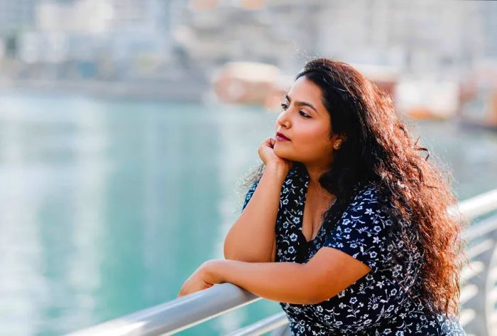 A woman with curly hair is lost in thought.