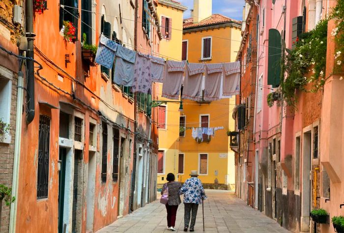 DEST_ITALY_VENICE_Two old women walking along Sotoportego de le Colone in Venice_GettyImages-855353558