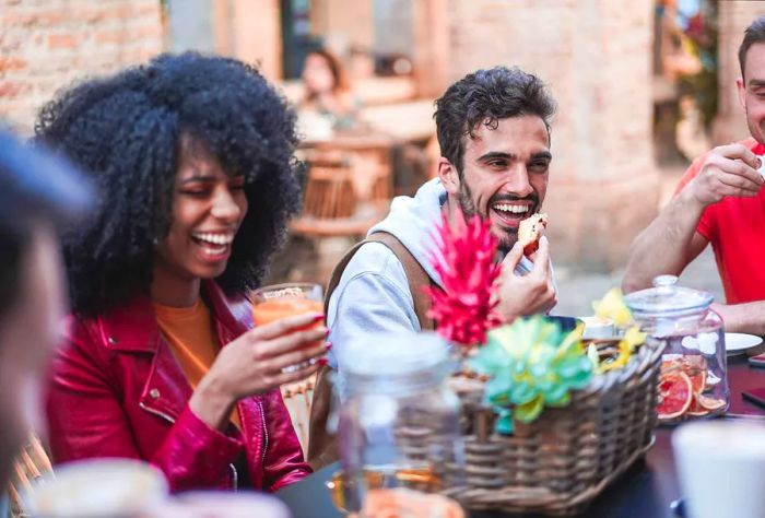 A cheerful group of friends enjoying coffee and laughter together.