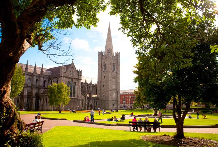 Visitors enjoying a sunny day in the park near St. Patrick's Cathedral.