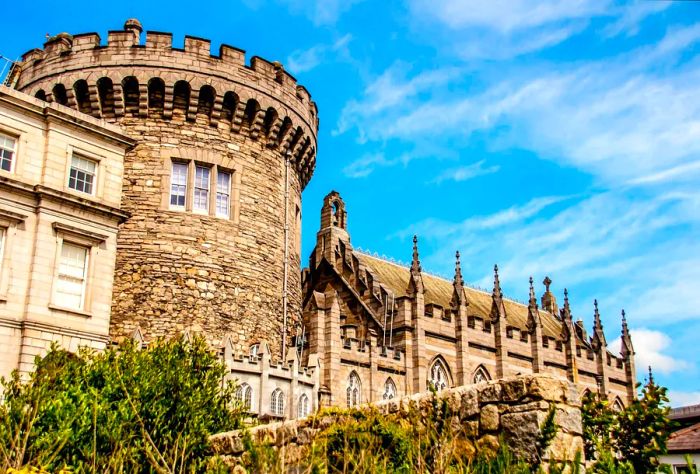 A historic medieval fortress featuring a round tower next to a gothic revival chapel.