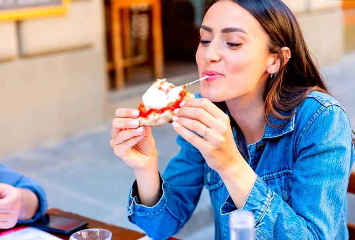 THEME_FOOD_PEOPLE_WOMAN_EATING_PIZZA_GettyImages-1327239745