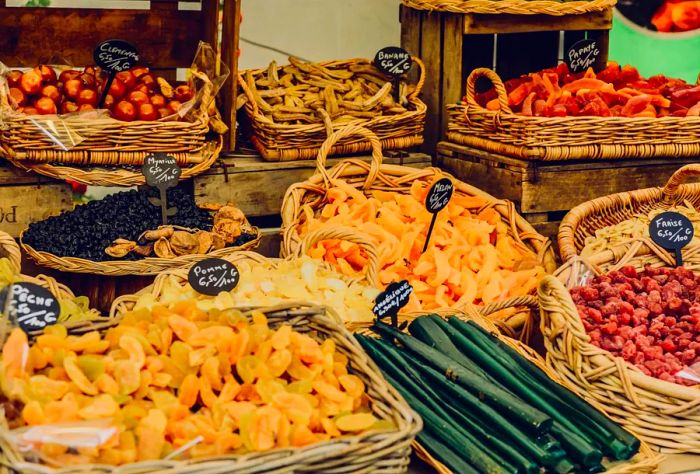 Colorful dried fruits and vegetables showcased at a Parisian food market.