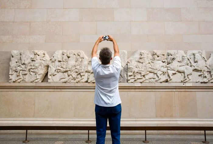 DEST_UK_ENGLAND_LONDON_BRITISH_MUSEUM_MAN_TAKING_PHOTO_OF_CARVING_GettyImages-200522795-001