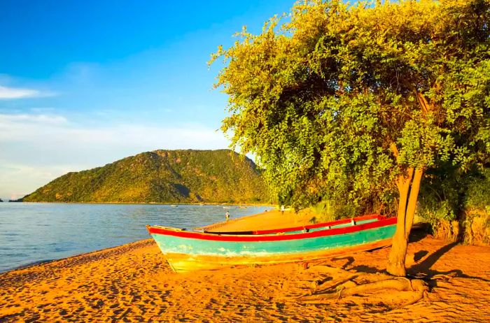 A boat resting on the beach at Cape Maclear, situated on the shores of Lake Malawi, Africa.