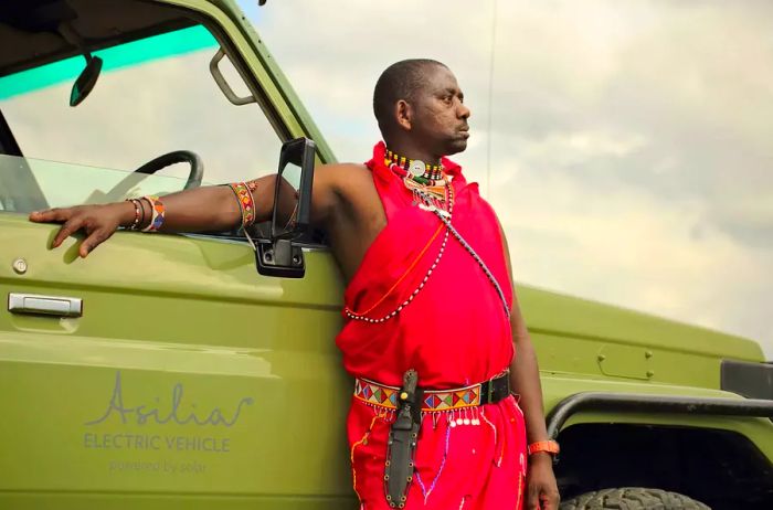 Massai guide Duma beside an Asilia electric vehicle