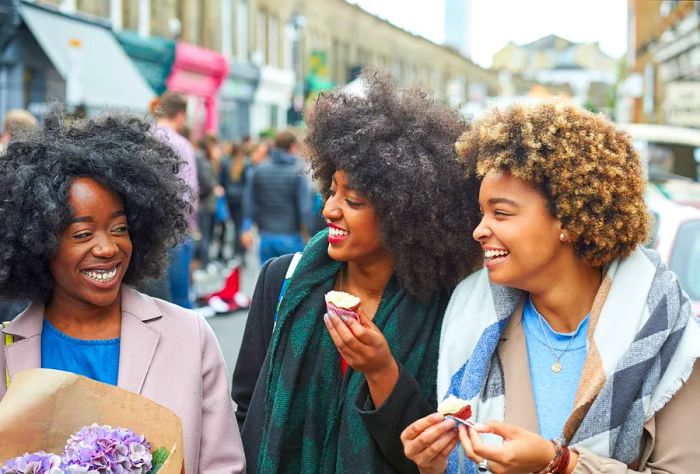 DEST_ENGLAND_UK_LONDON_PEOPLE_WOMEN_FLOWERS_FOOD_EATING_CUPCAKES_GettyImages-587113123