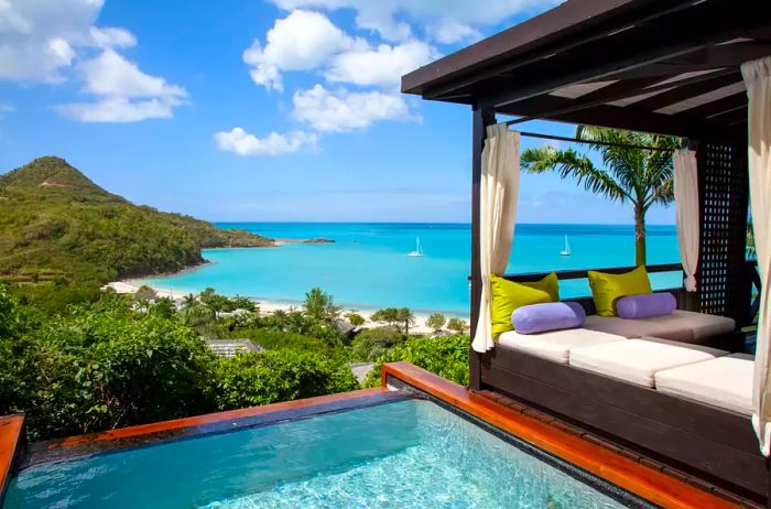 A day bed and pool with ocean views at Hermitage Bay