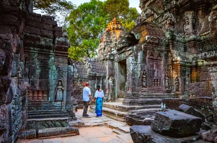 A couple of adult tourists exploring the ancient temple ruins in Siem Reap, Cambodia