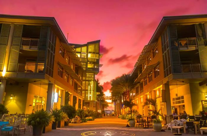 A vibrant pedestrian area illuminated at sunset in a waterfront town of Grand Cayman