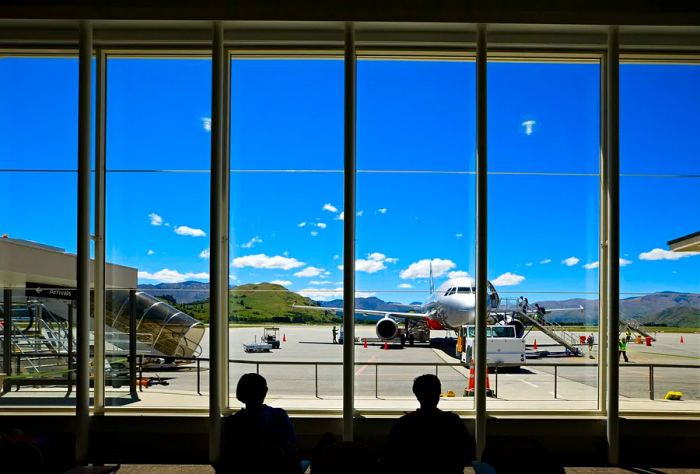 An airport view with a silhouette of travelers