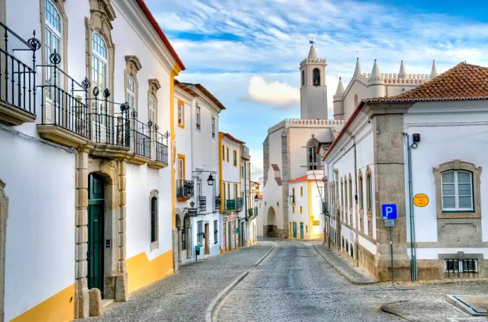 The charming streets of Évora, Portugal, and the Capela dos Ossos (Chapel of Bones) nearby. This small interior chapel is situated next to the entrance of the Church of St. Francis, earning its name from the walls that are adorned with human skulls and bones.