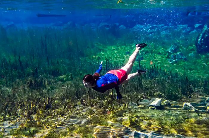 A young girl enjoying a swim in the Blue Heart Springs of Idaho