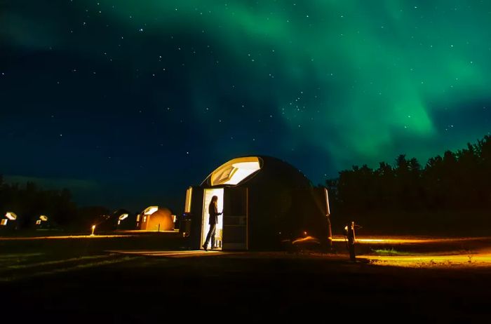 A guest dome at Métis Crossing, illuminated by the northern lights.