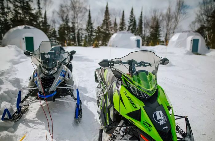 Snowmobiles parked in front of the domes at Station Boréale in Canada