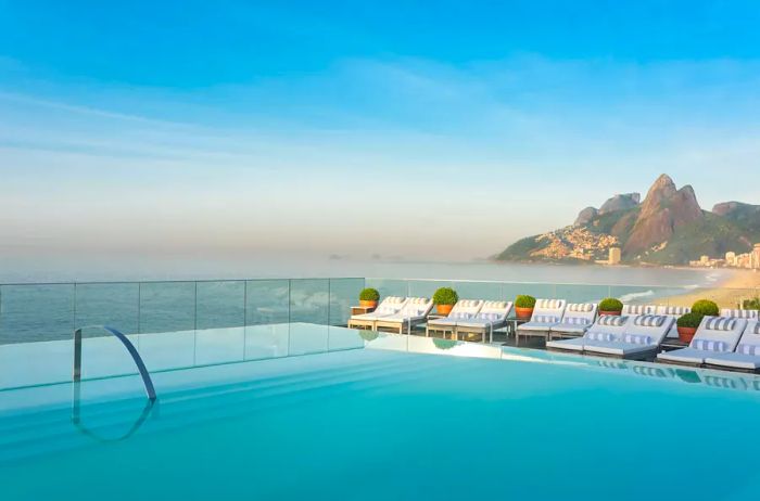 An infinity pool offering breathtaking views of the ocean framed by distant mountains.