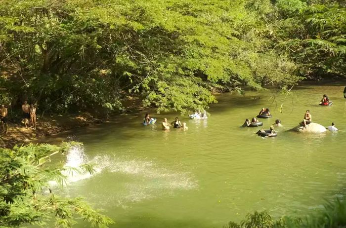 Individuals swimming and floating along a river in San Rafael, Colombia.