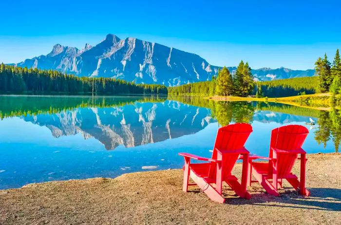 A serene landscape showcasing Mt Rundle reflecting in Two Jack Lake, Banff National Park, Alberta, Canada on a sunny morning.