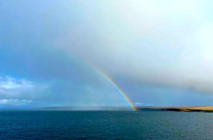 A vibrant rainbow arcs over the ocean as seen from the Aqua Mare ship