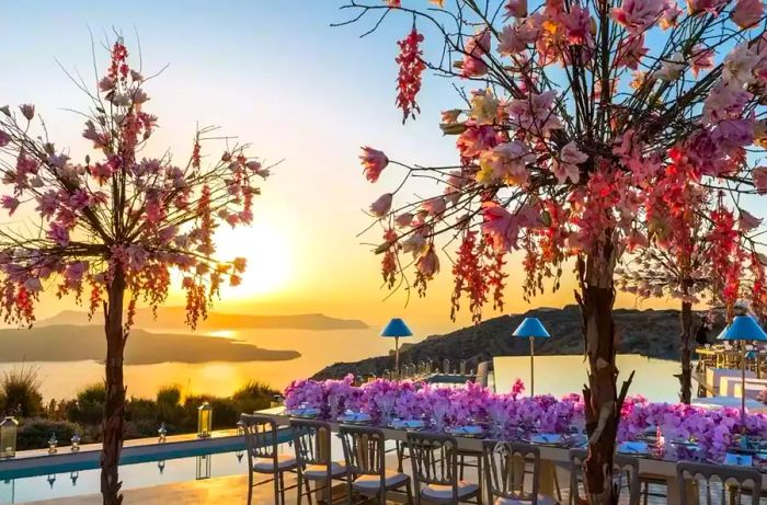 Dining table adorned with flowers, offering ocean views at sunset