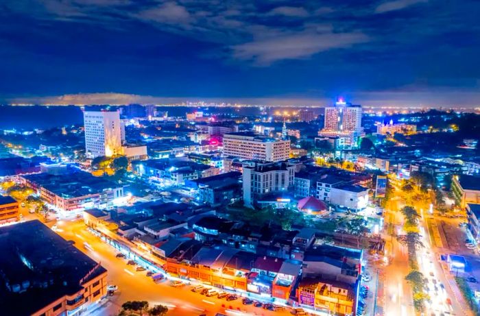 Aerial view showcasing Batam City's vibrant cityscape at night, illuminated with lights, Indonesia, Asia