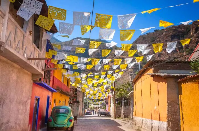 A quiet street featuring traditional Mexican houses with low architecture, vibrant colors, and a lively atmosphere. San Cristobal de las Casas, Chiapas, Mexico