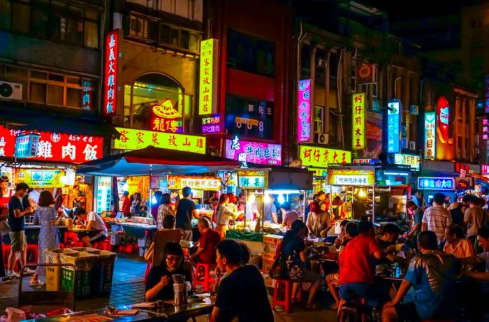 Crowds enjoying food and drinks at Ningxia Road Night Market, a renowned snack street in Taipei City