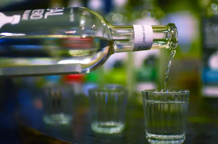 A bottle of Sotol being poured