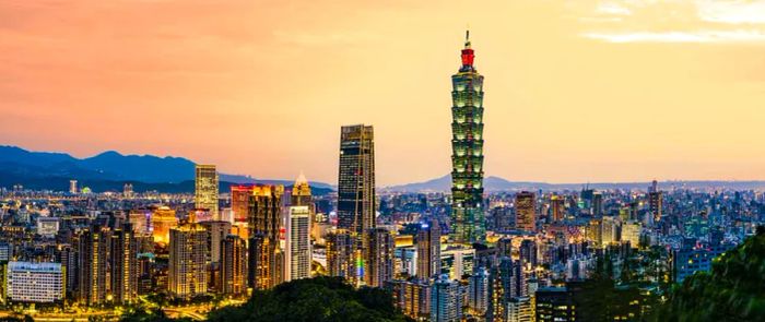 A breathtaking aerial view of the Taipei City skyline, beautifully illuminated at sunset. Panoramic vista from Elephant Mountain, Taipei, Taiwan.