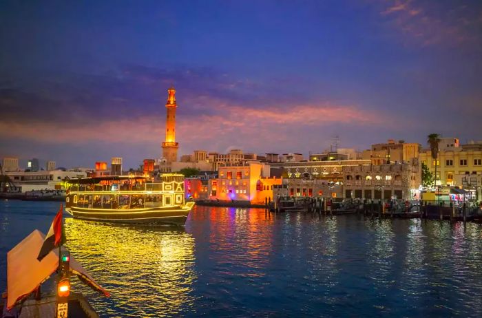 A ferry gliding down Dubai Creek at night