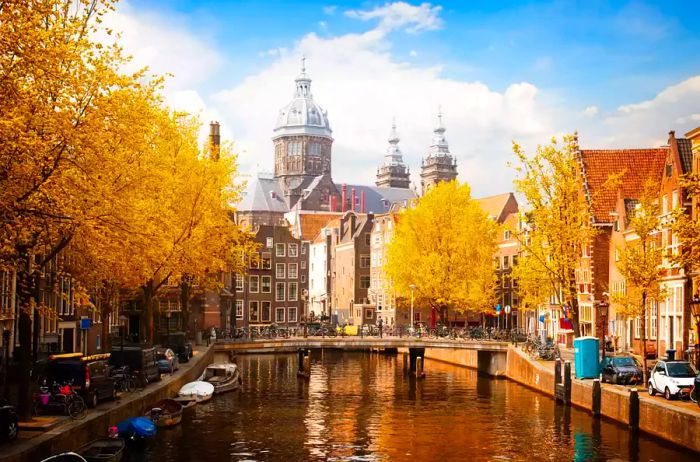 St. Nicholas Church and an old town canal in Amsterdam during autumn, showcasing fall colors