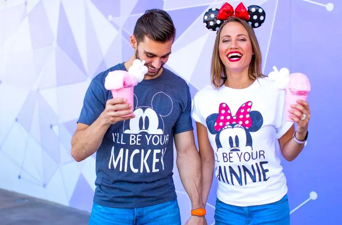 Newlywed couple savoring desserts in matching Disney t-shirts